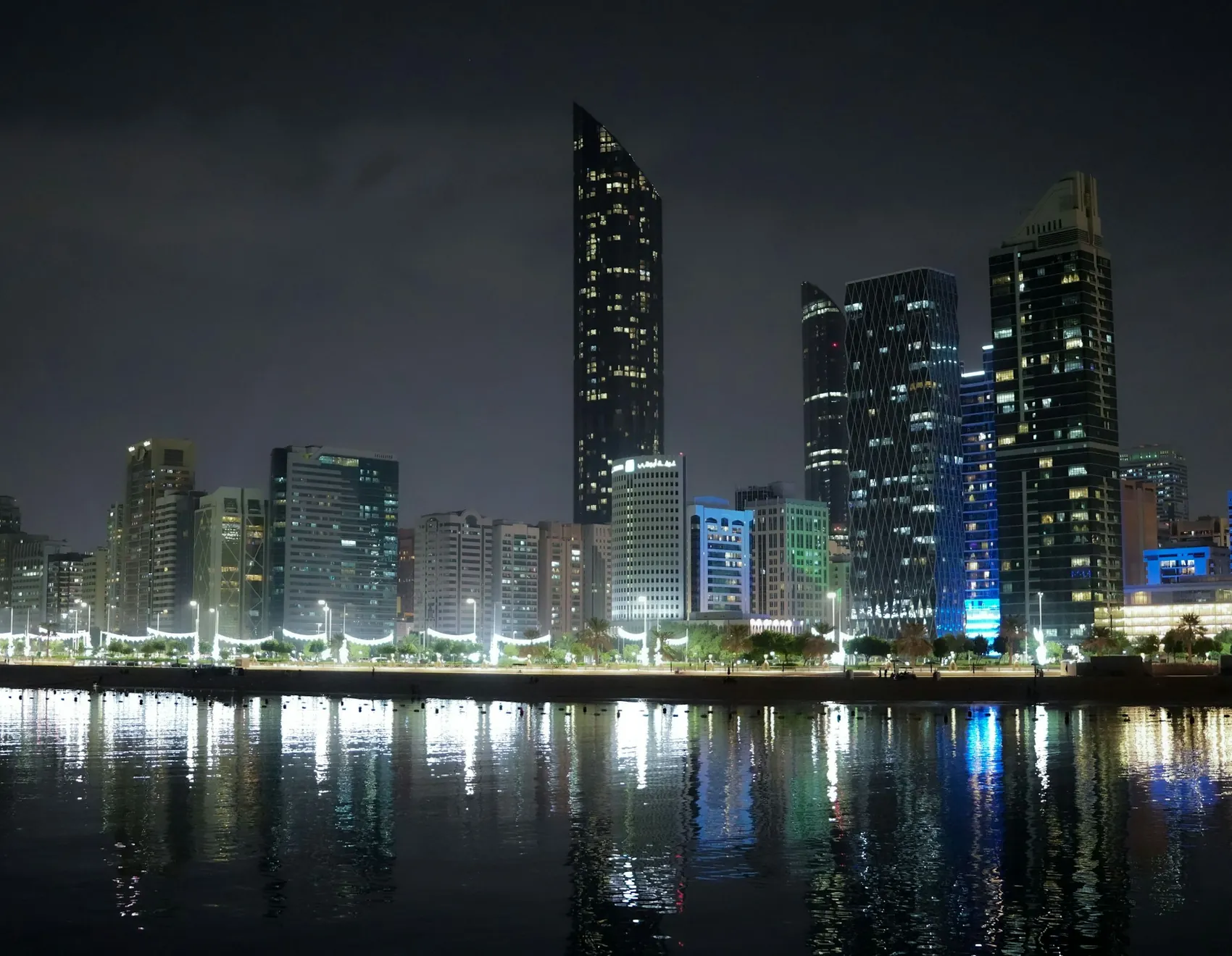 Abu Dhabi skyline at night reflected in the water