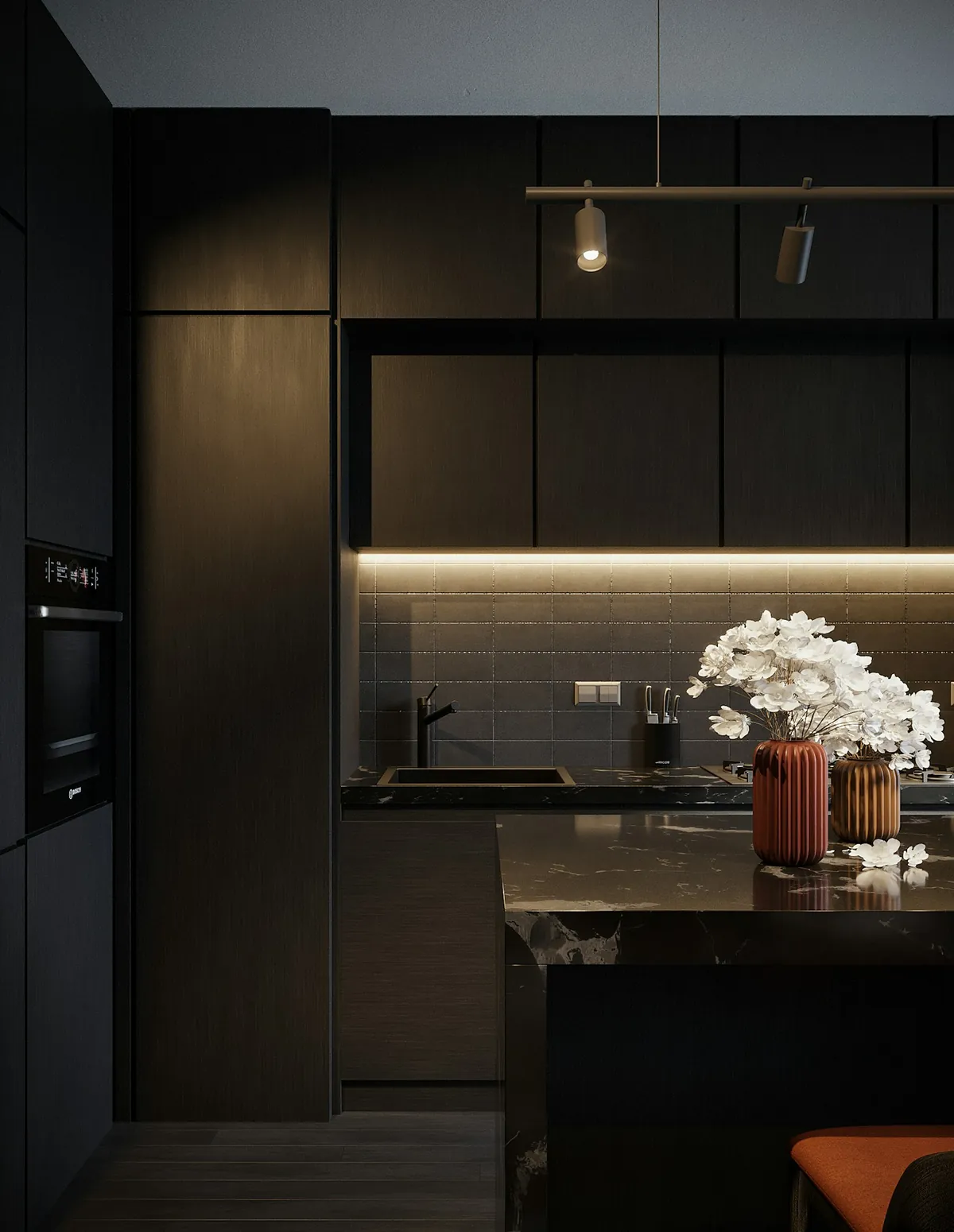 Dark fitted kitchen with stone island and under-cabinet lighting